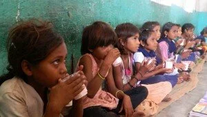 Children drink milk from plastic glasses